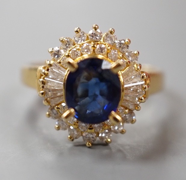 A modern 750 yellow metal, sapphire and diamond set oval cluster ring, size H, gross weight 4.6 grams.